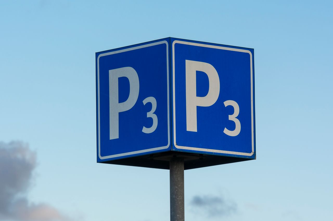 Close-up of a P3 parking sign on a metal post, set against a clear blue sky.